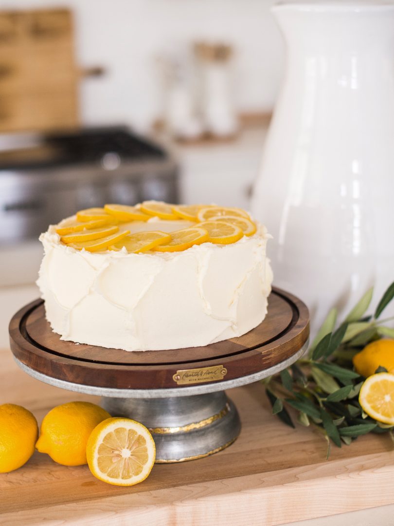 Cake by Courtney - Chocolate Lemon Zucchini Cake #chocolatecake #chocolatezucchinicake #lemoncreamcheesefrosting #chocolatelemonzucchinicake Cake on a cake stand in a kitchen.