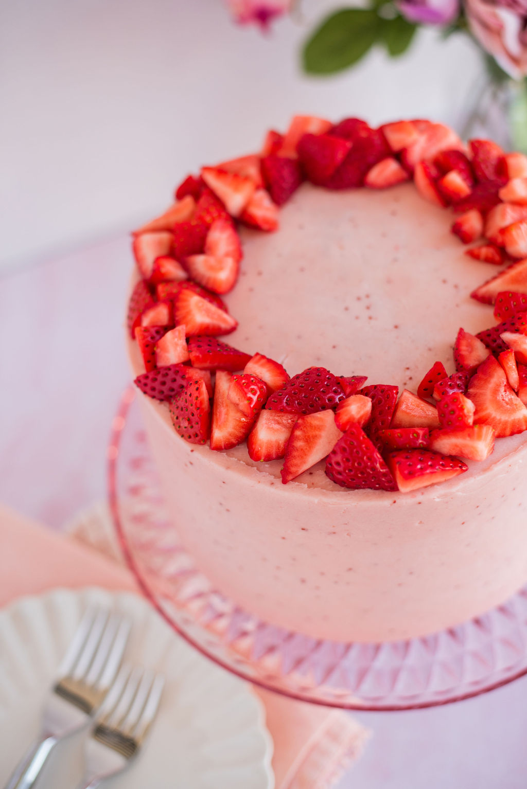 A strawberry cake on a cake stand.
