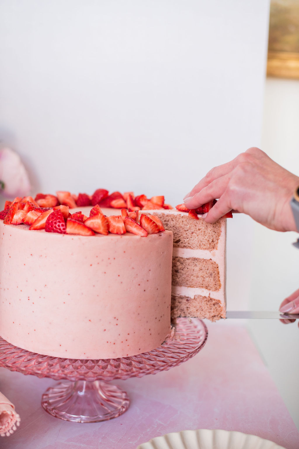 A slice of cake being taken out of a full cake.