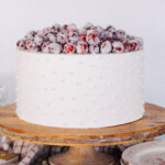 Cake on a cake stand with candied cranberries.
