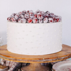 Cake on a cake stand with candied cranberries.
