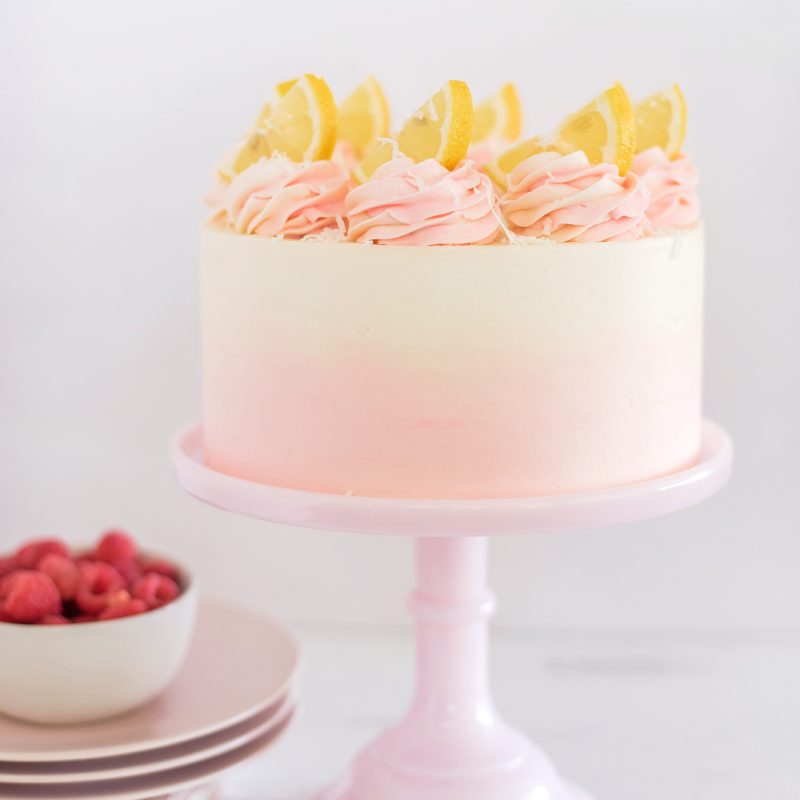 Coconut Lemon Raspberry Cake - coconut cake layers, lemon curd, raspberry cream filling, and coconut buttercream. #cakebycourtney #coconutcake #bestcoconutcake #lemoncurd #raspberrycream #raspberryfilling #coconutbuttercream #summercake #bestsummerdessertrecipes #summercakes #summerdessertrecipes