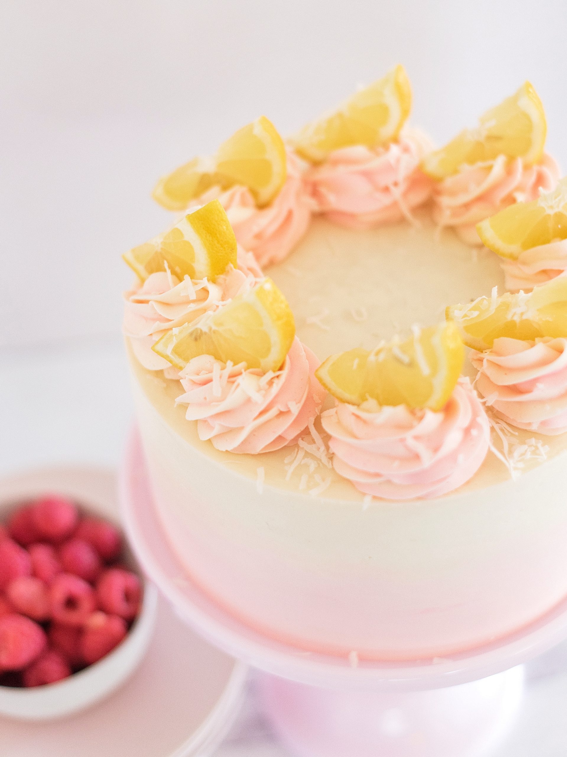Coconut Lemon Raspberry Cake on a cake stand.