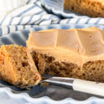 A slice of peanut butter sheet cake with a bite on the fork.