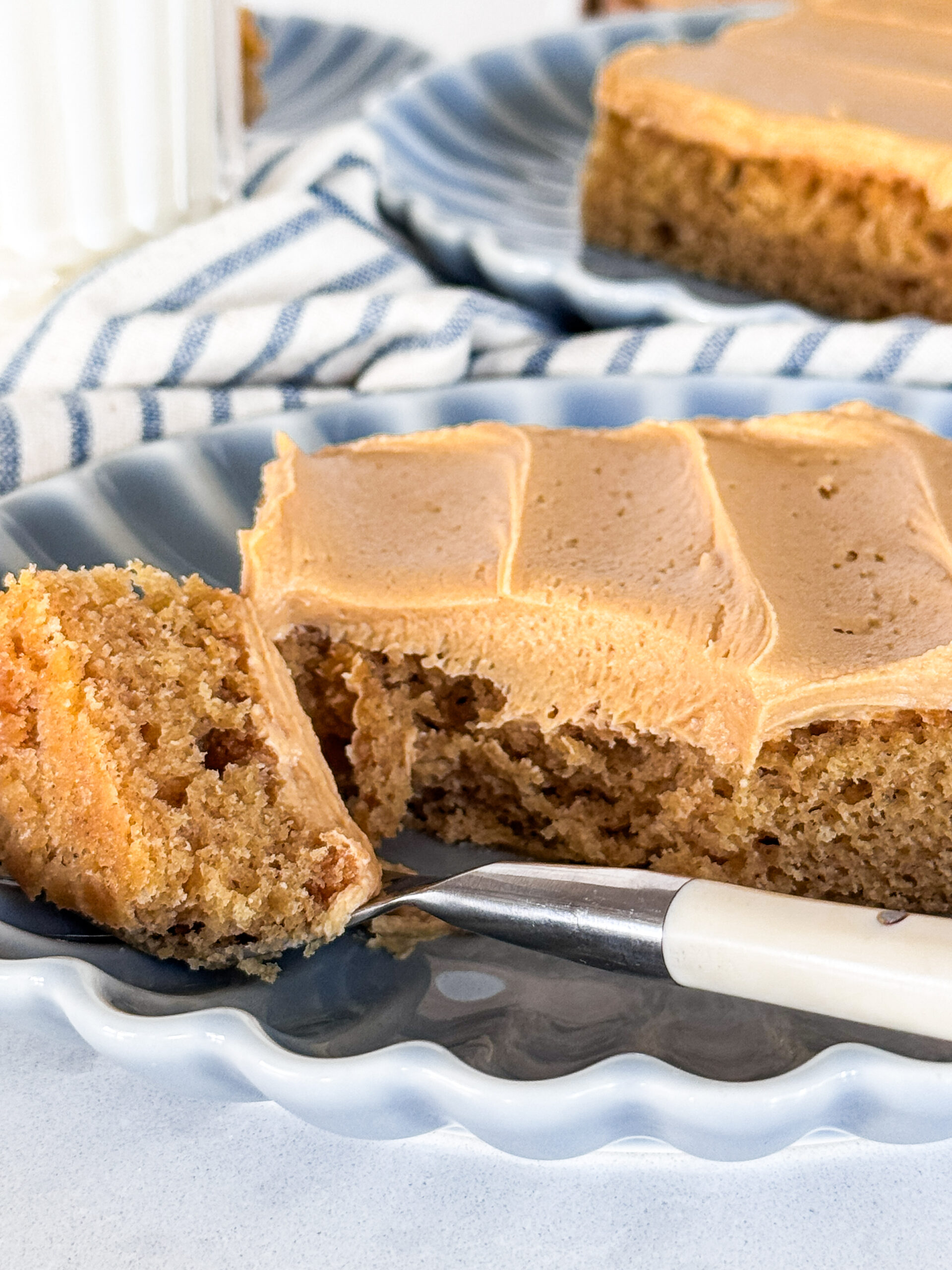 A slice of peanut butter sheet cake with a bite on the fork.