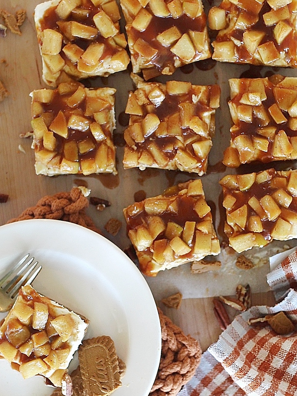 Overhead view of caramel apple cheesecake bars on a cutting board.